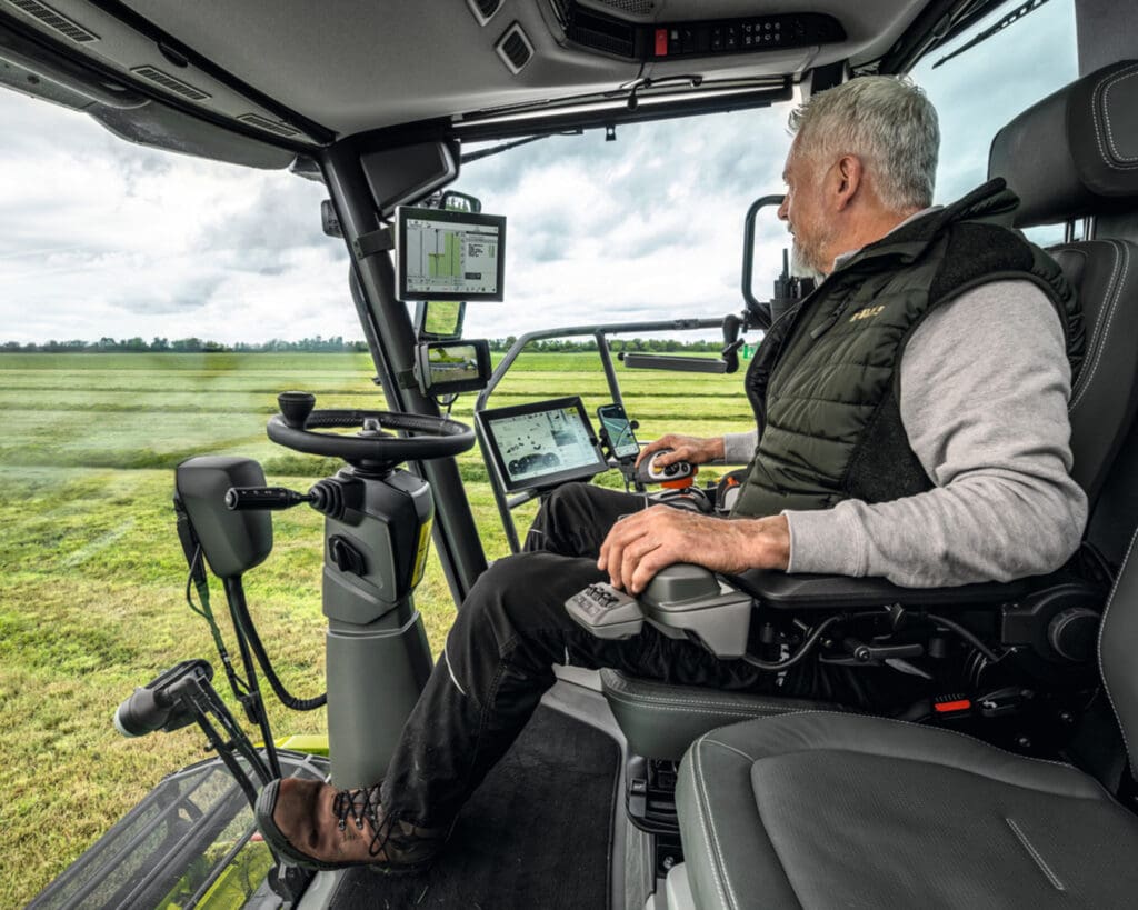A close-up shot of a modern operator cabin interior, focusing on a digital display or telematics screen, representing advanced technology and safety.